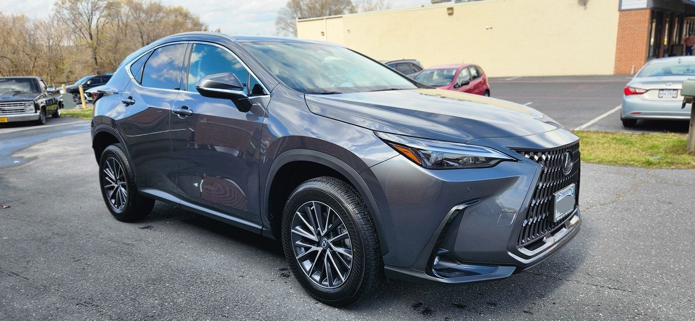 A brown sports car is parked in a parking lot in front of a building.