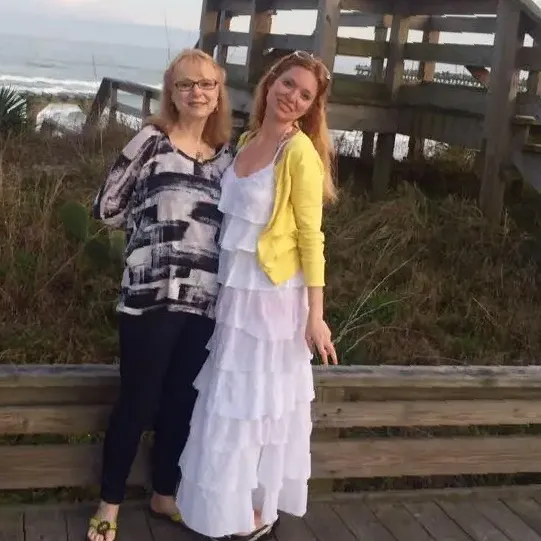 Two women standing next to each other on a beach