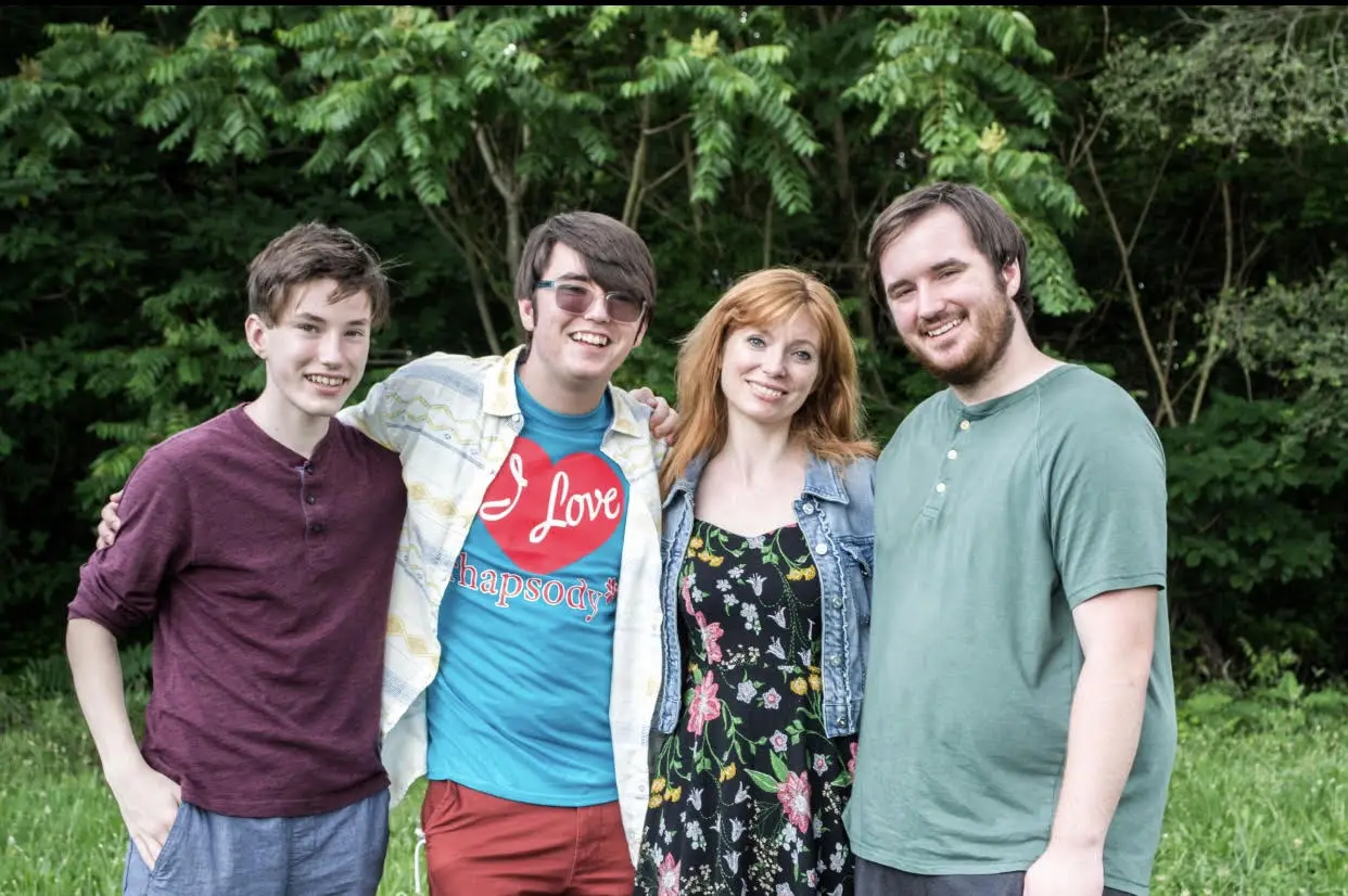 A group of people are posing for a picture in a field.