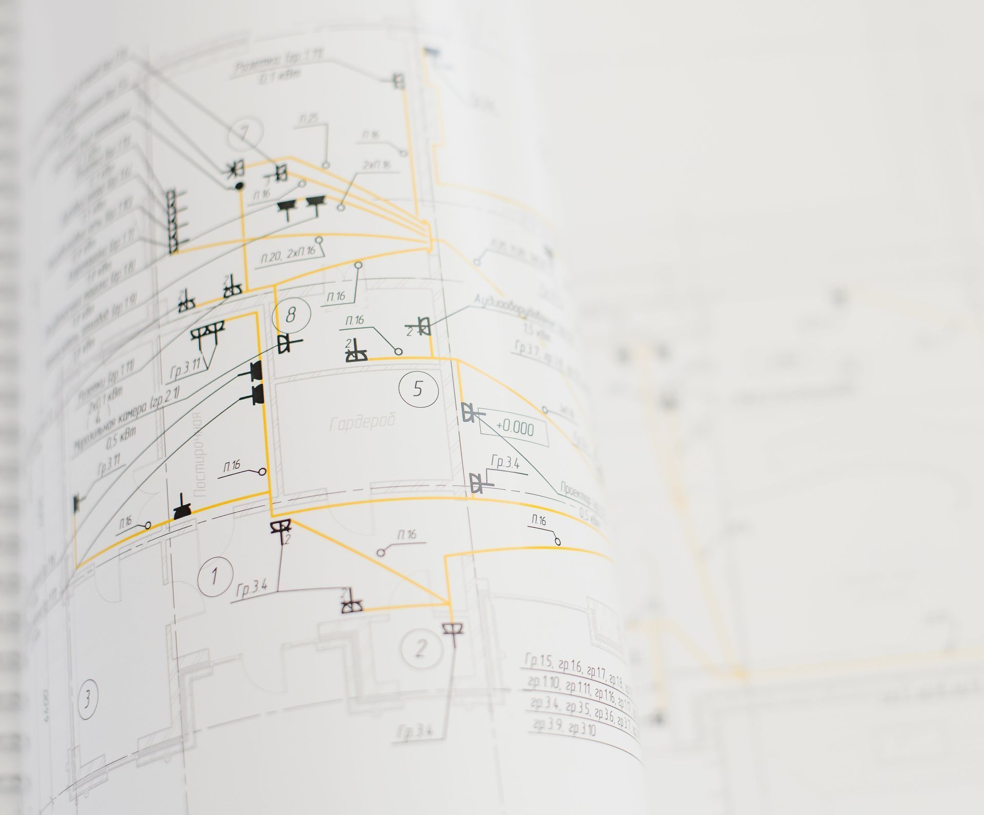 Architectural blueprint with black and yellow lines, rolled slightly.