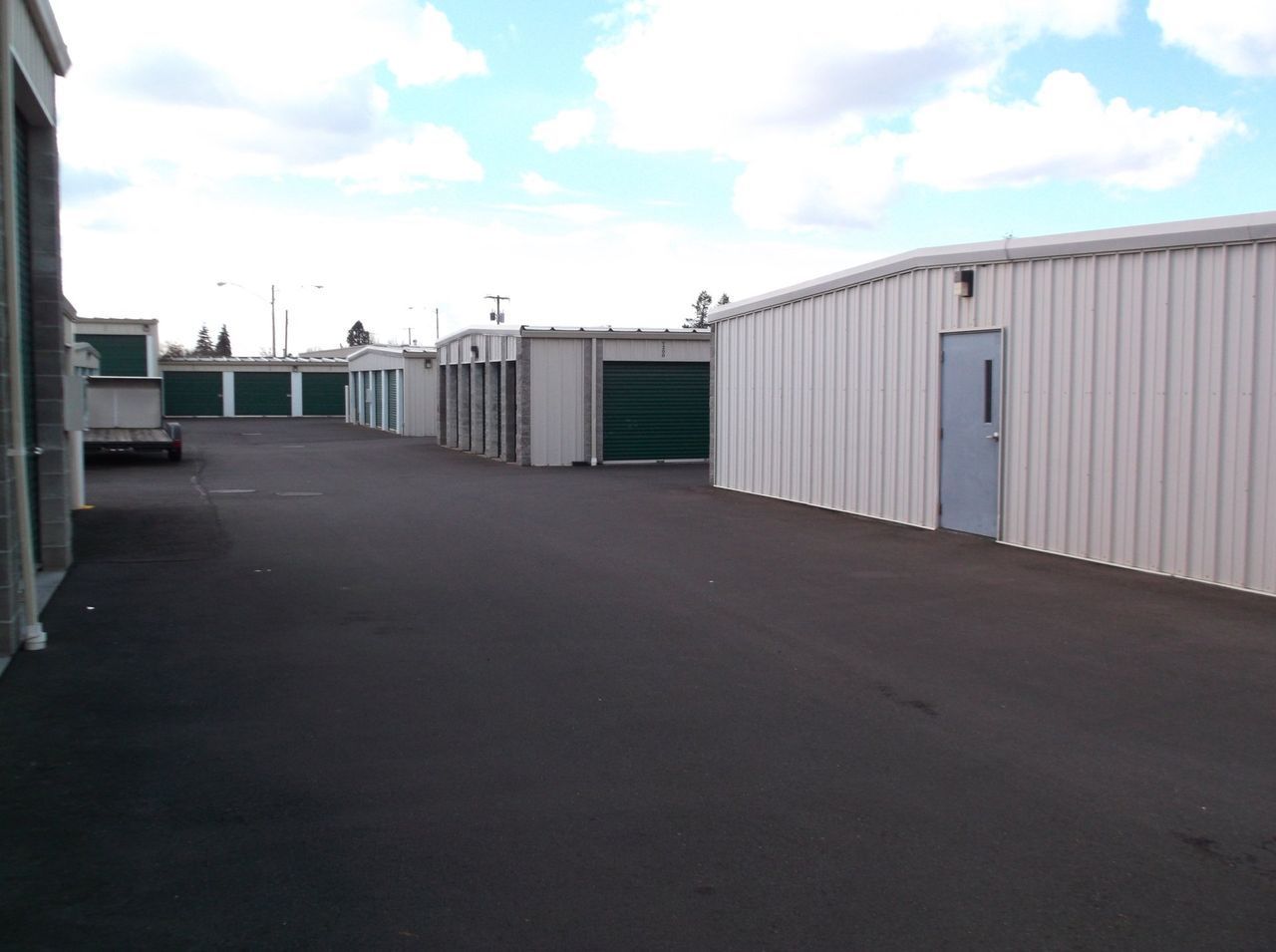 A row of storage units with green doors and white walls – Springfield, OR - 42nd St Mini Storage