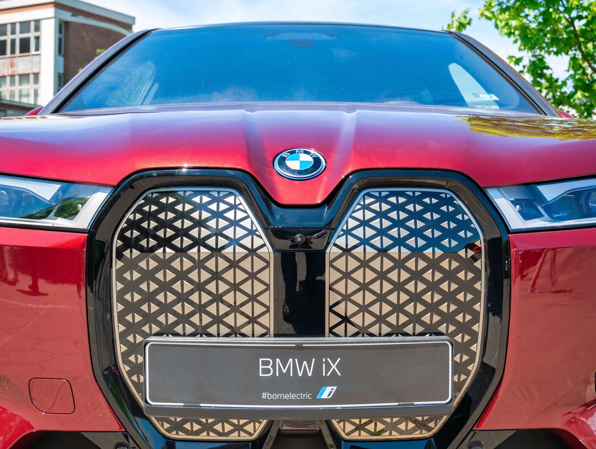 The front of a red bmw ix is shown.