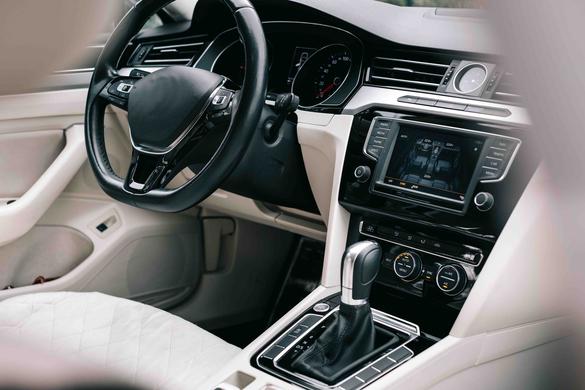 The interior of a car with a steering wheel and a radio.