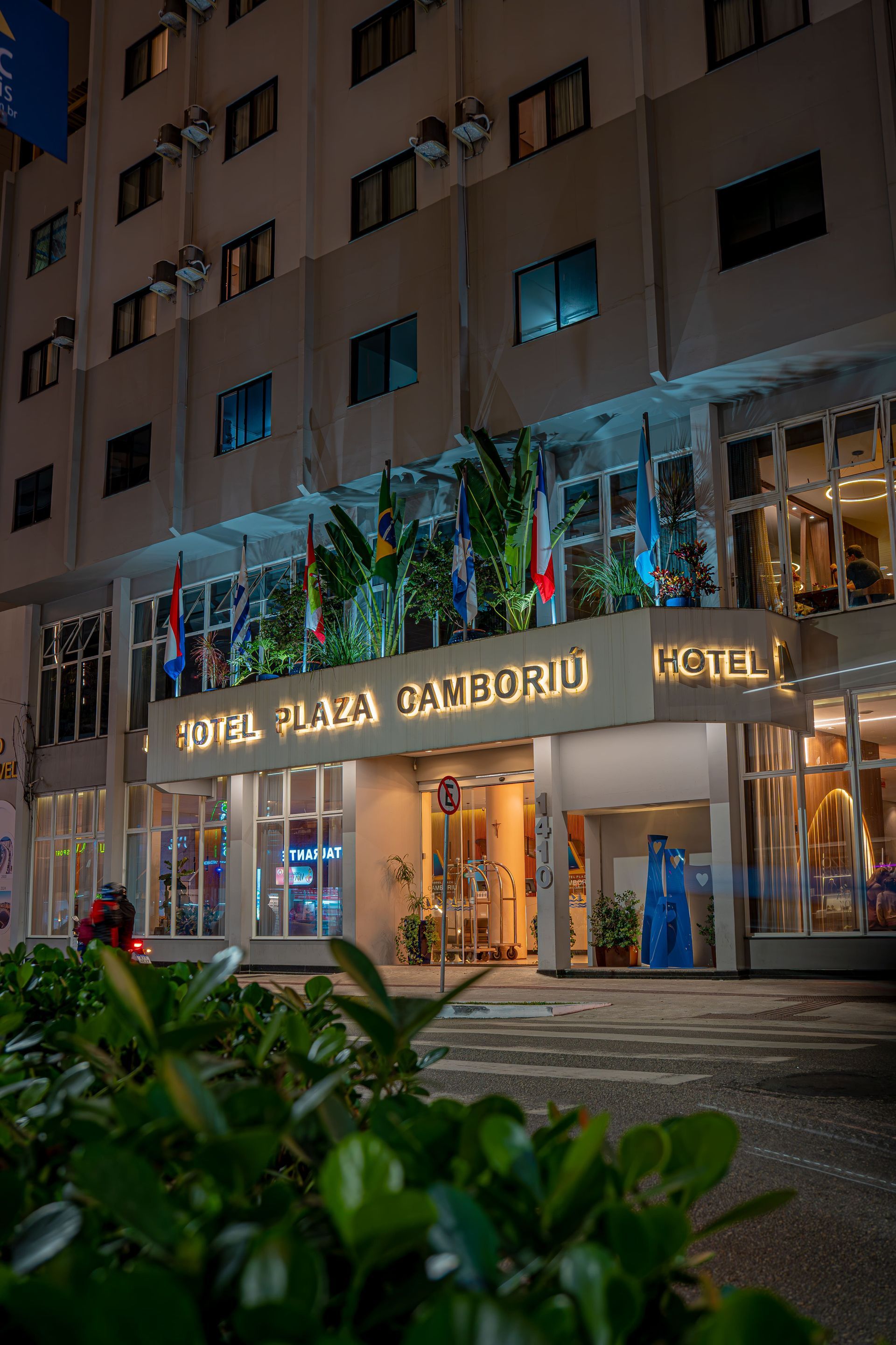 Hotel Plaza Camboriú, prédio branco com sinalização, bandeiras.