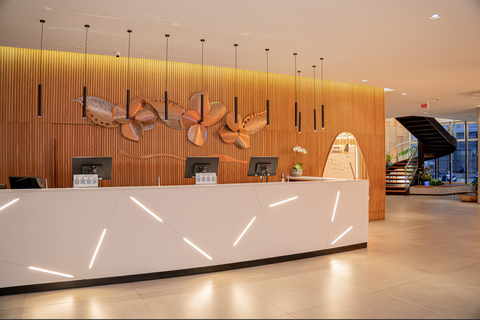 Vista de alto ângulo de uma cidade densa com prédios altos, ruas e carros sob um céu claro.