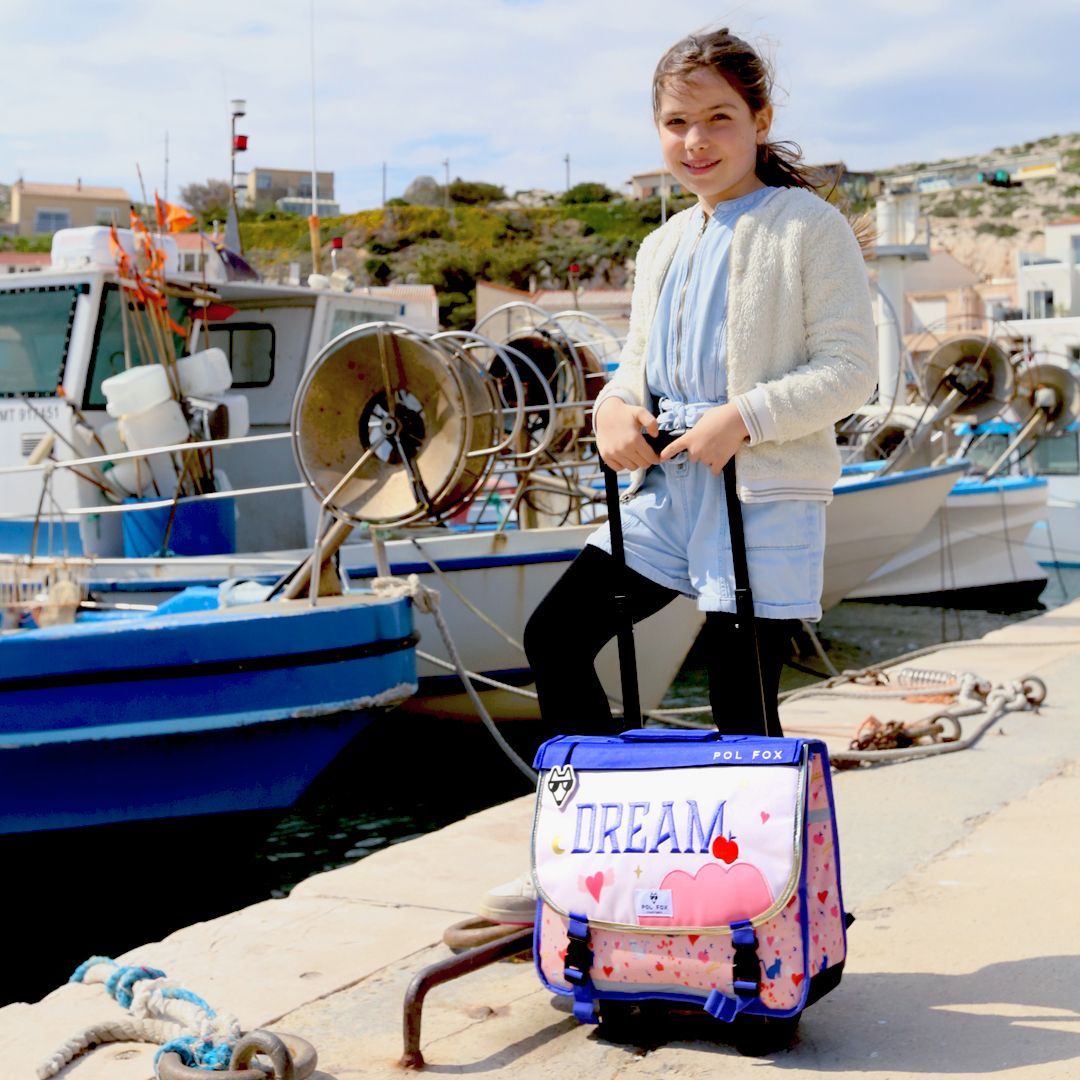 Enfant avec cartable à roulettes dans un univers voyage Pol Fox