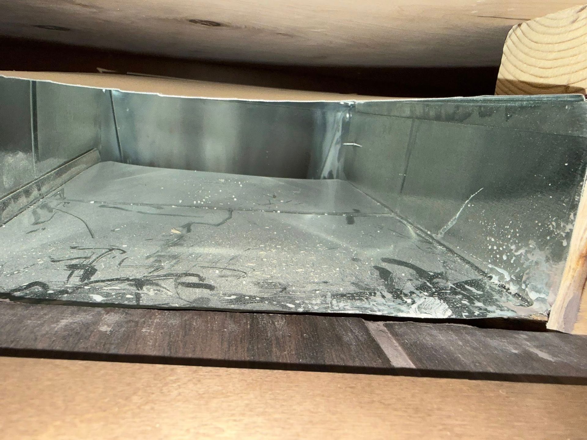 Empty metal fireplace insert with ash residue and soot inside