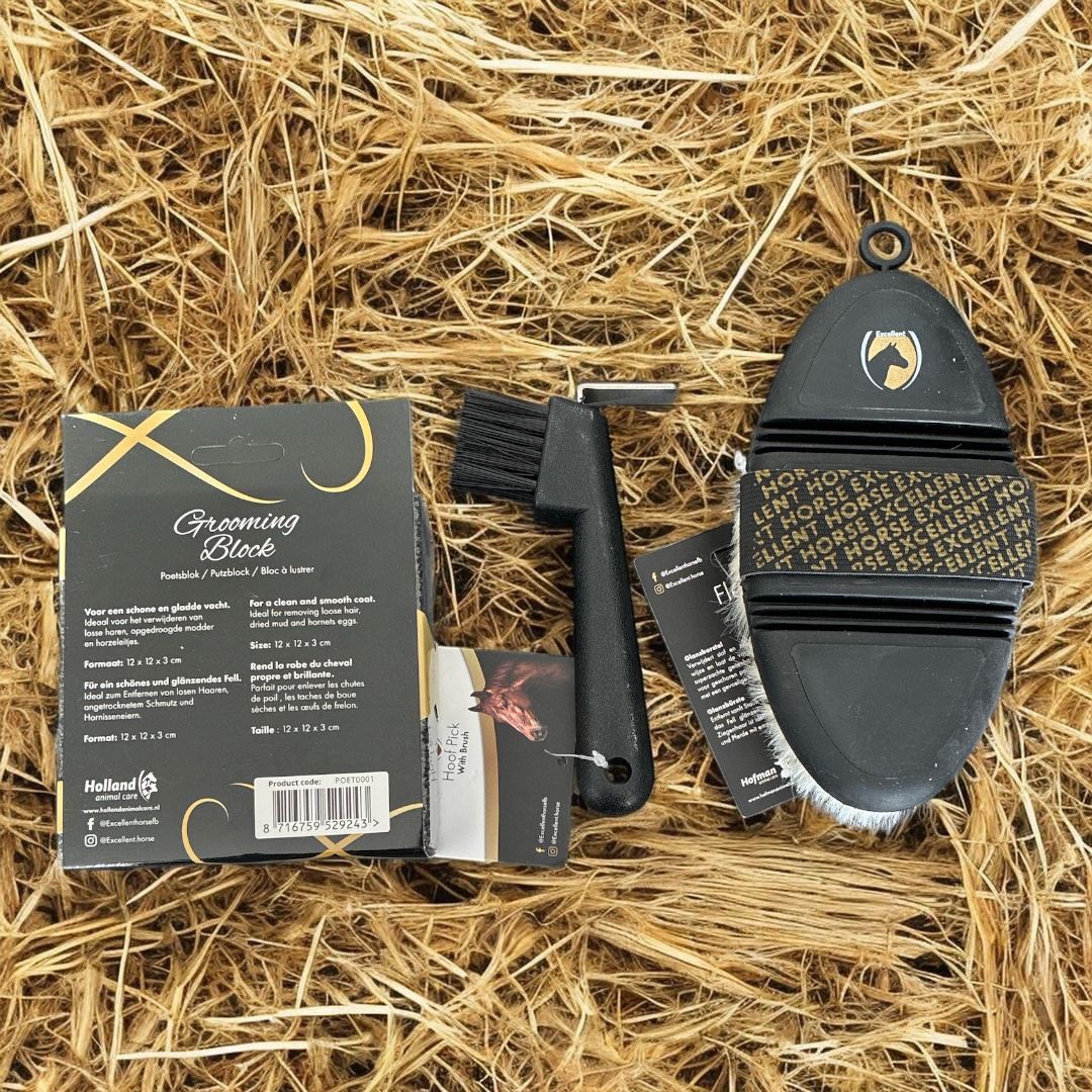 Een complete paardenverzorgingsset met een reinigingsborstel en een ovale roskam met zachte haren, op een bedje van hooi.