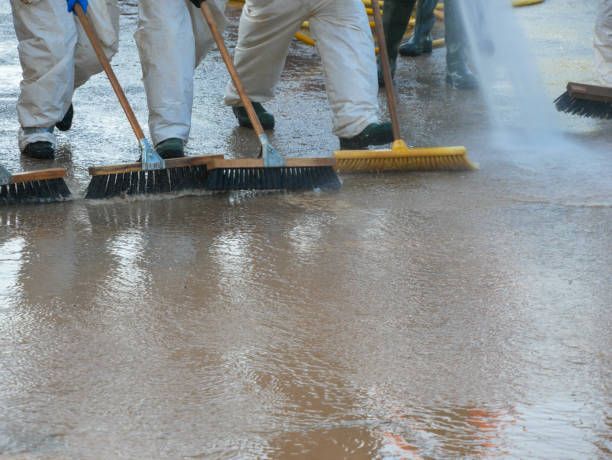 Workers using squeegees for professional flood water removal.