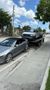 A car is being towed by a tow truck on the side of the road.