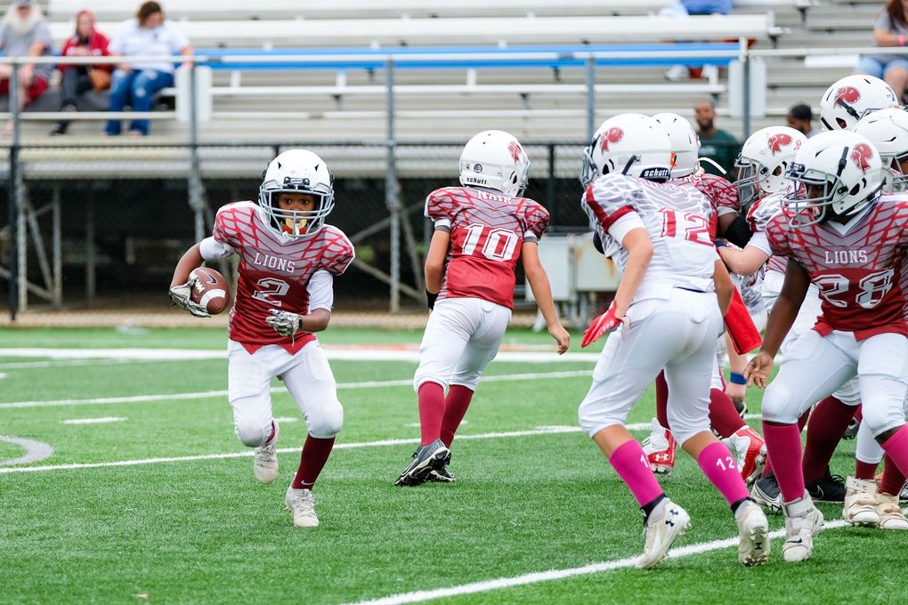 A group of young boys are playing football on a field.