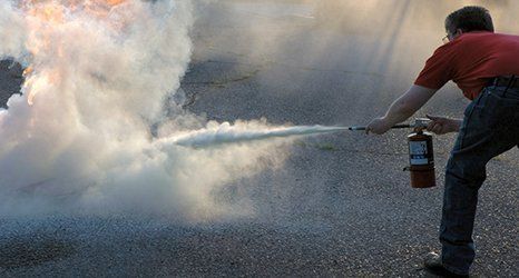 A man trying to control the fire with a fire extinguisher