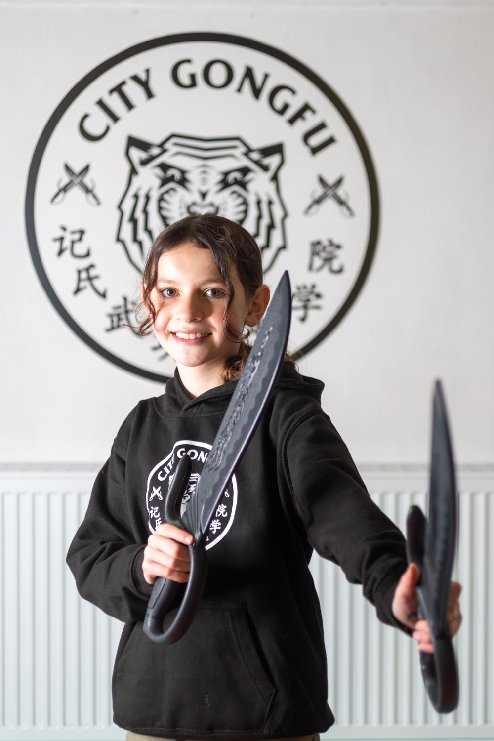 a little girl wearing a white shirt that says Citygongfu