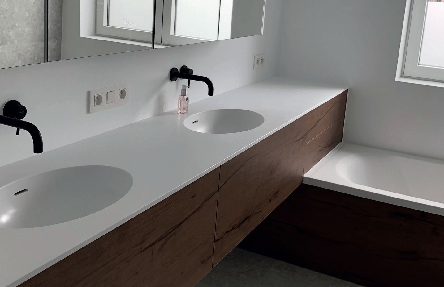 Een badkamer met twee wastafels en een ligbad.