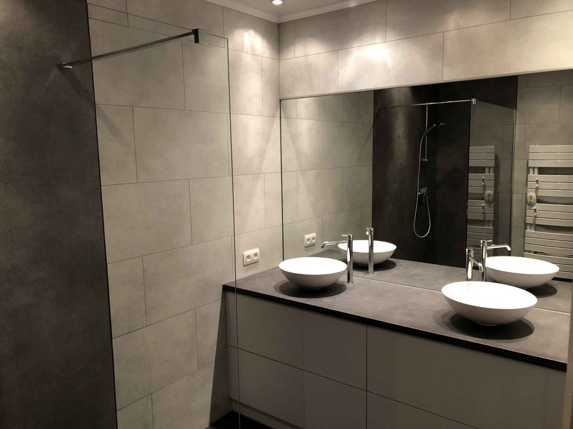 Een badkamer met twee wastafels en een grote spiegel