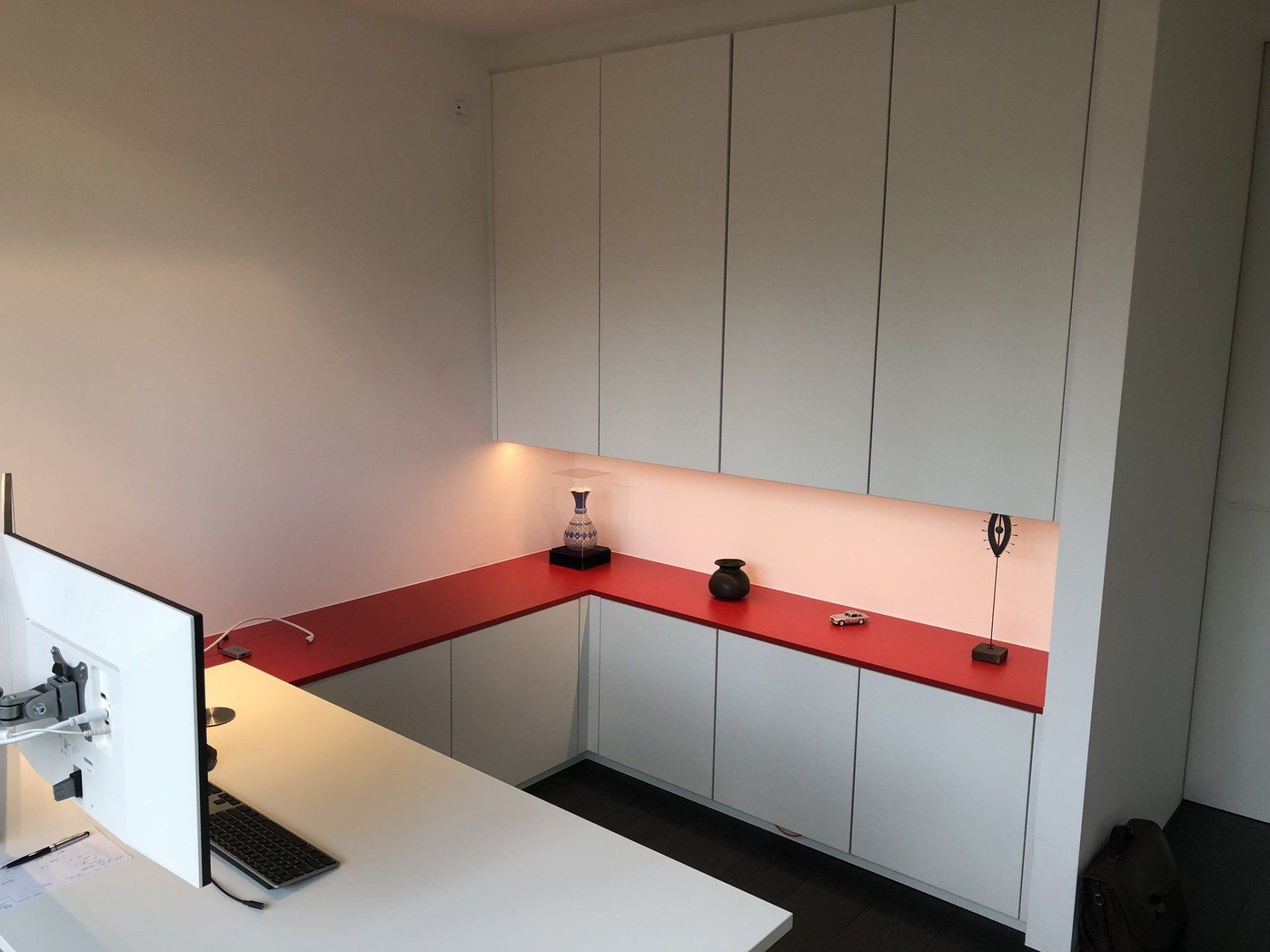 Een bureau met een computer en een vaas erop