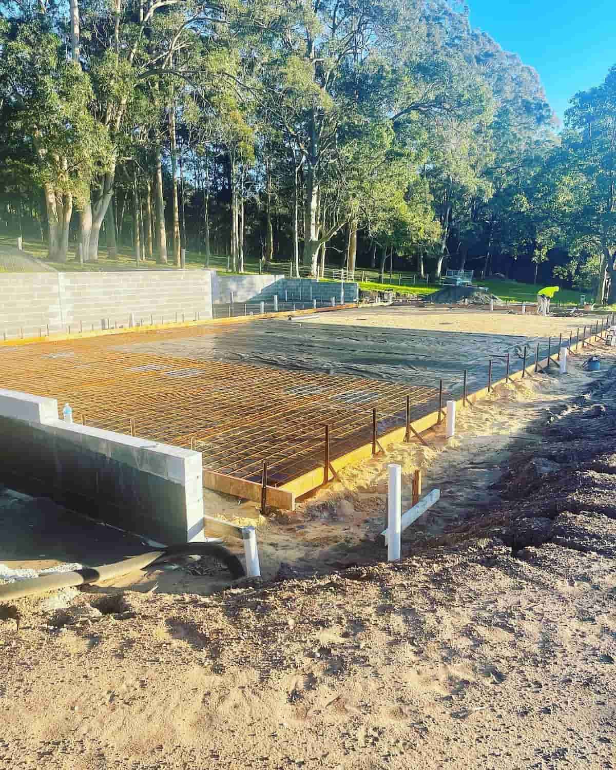 A Concrete Foundation Is Being Built In A Field With Trees In The Background — Tuncote Concrete Constructions in Raymond Terrace, NSW