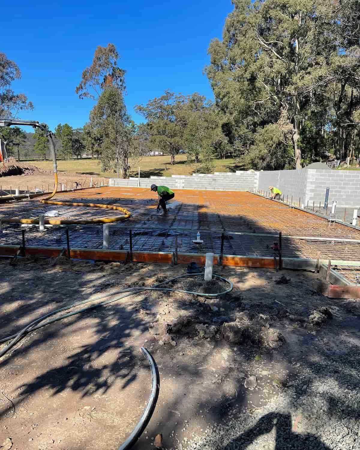 A Man Is Working On A Concrete Base In A Field — Tuncote Concrete Constructions in Anna Bay, NSW