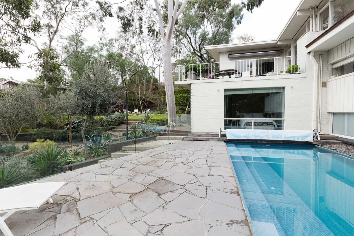 A Large House With A Swimming Pool In Front Of It — Tuncote Concrete Constructions in Anna Bay, NSW