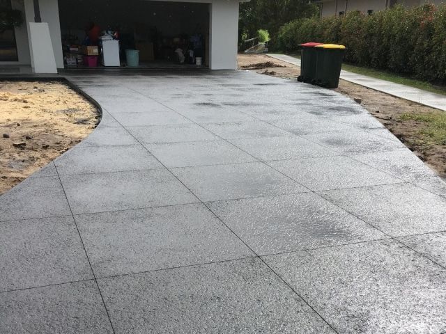 A Concrete Walkway Leading To A Garage Next To A Trash Can — Tuncote Concrete Constructions in Medowie, NSW