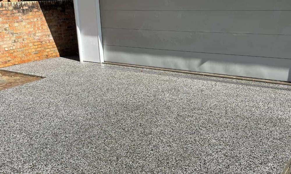 A Gray Carpet Is Sitting Next To A Garage Door — Tuncote Concrete Constructions in Anna Bay, NSW