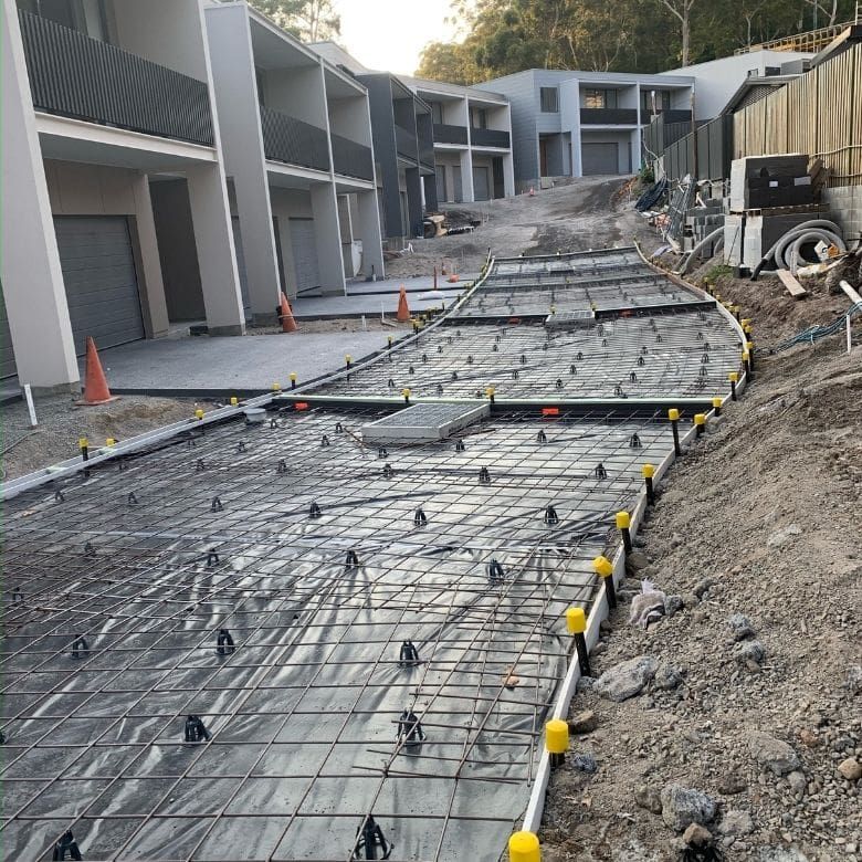 A Concrete Driveway Is Being Built In Front Of A Building — Tuncote Concrete Constructions in Salamander Bay, NSW