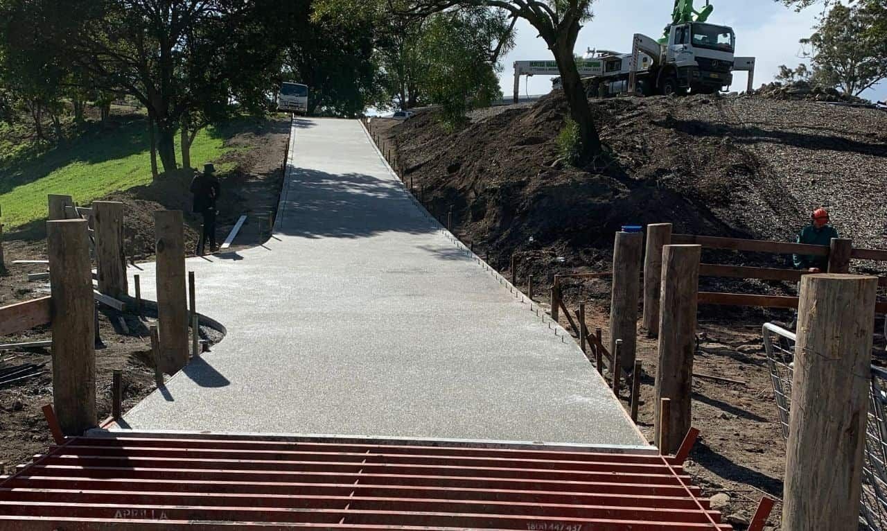 A Concrete Walkway Is Being Built Next To A Wooden Fence — Tuncote Concrete Constructions in Anna Bay, NSW