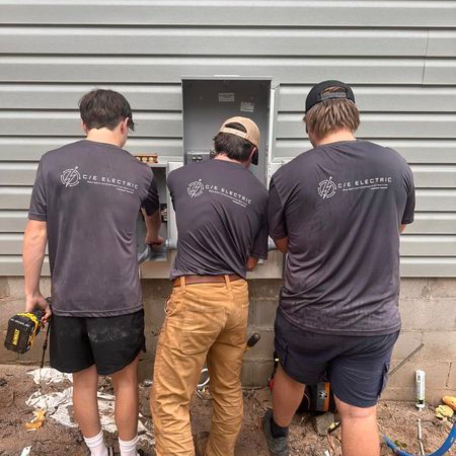 Three men wearing shirts with the word electric on the back
