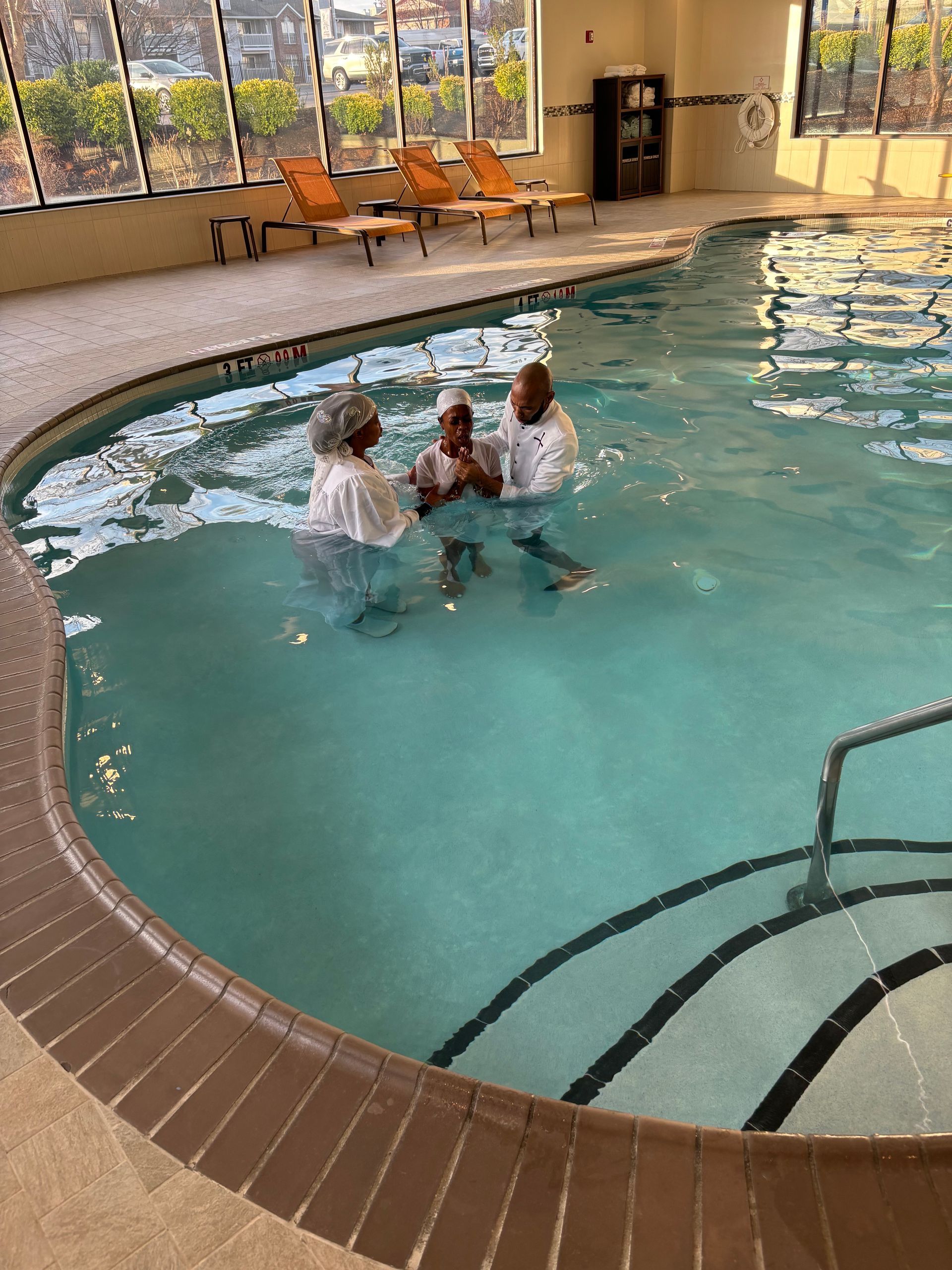 A group of people are standing in a swimming pool.