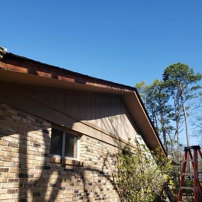 A ladder is sitting on the side of a brick house.