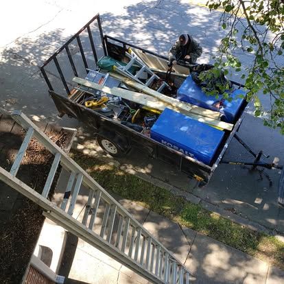 An aerial view of a trailer filled with tools and a ladder.