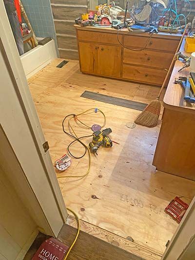 A room with a wooden floor and a book on the floor.