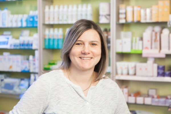 Eine Frau steht vor einem Regal in einer Apotheke.