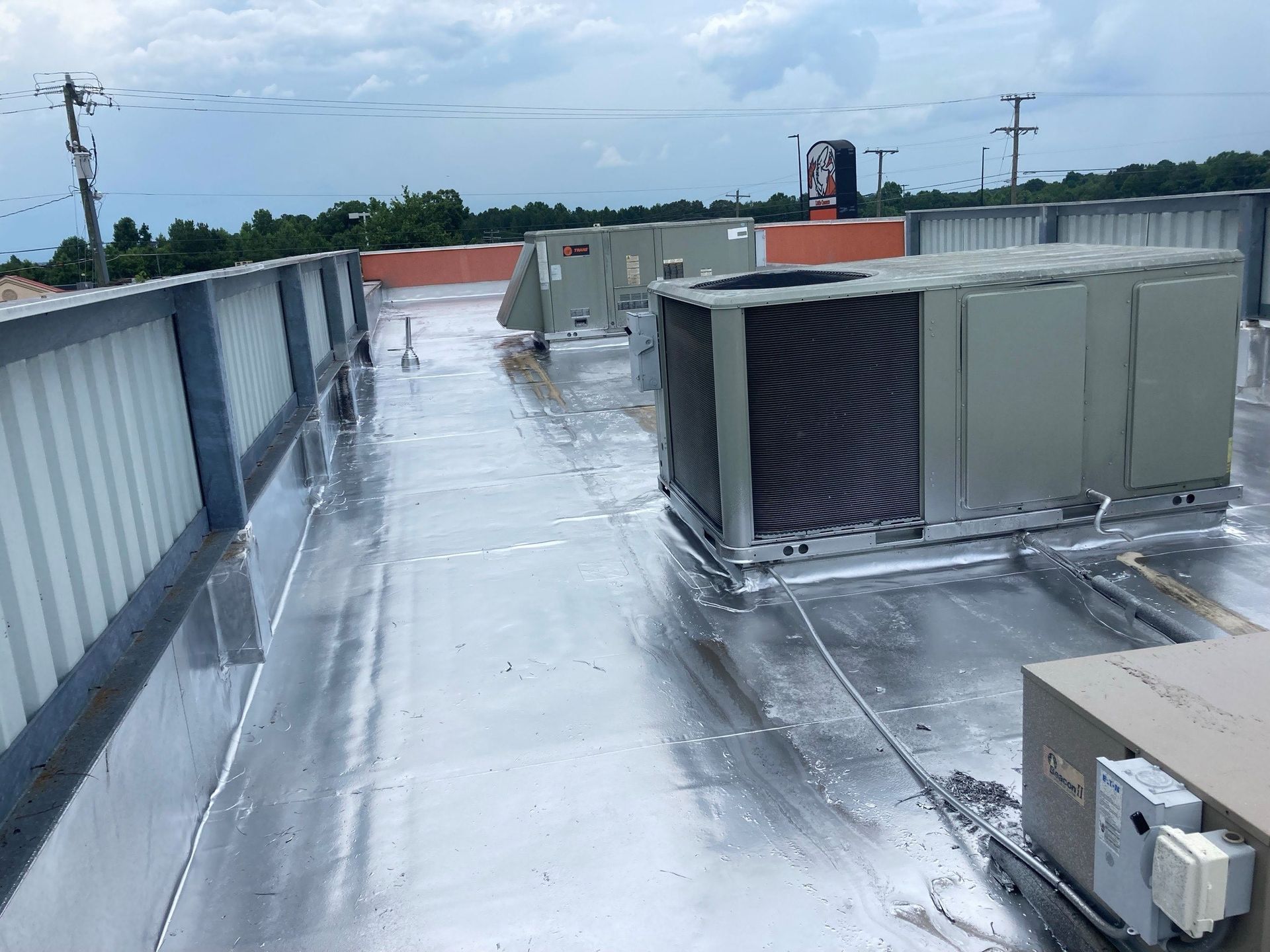 There are a lot of air conditioners on the roof of a building.
