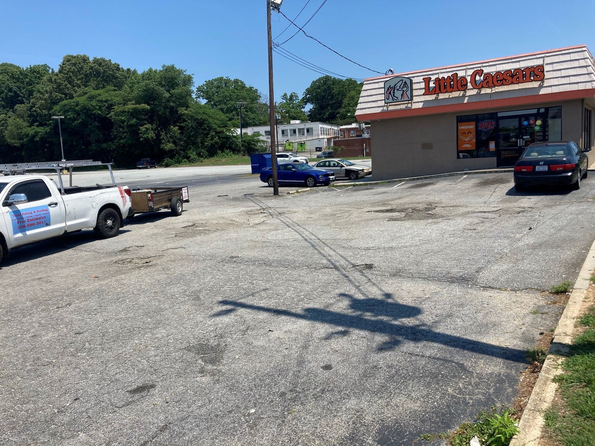 A white truck is parked in front of a laundromat.