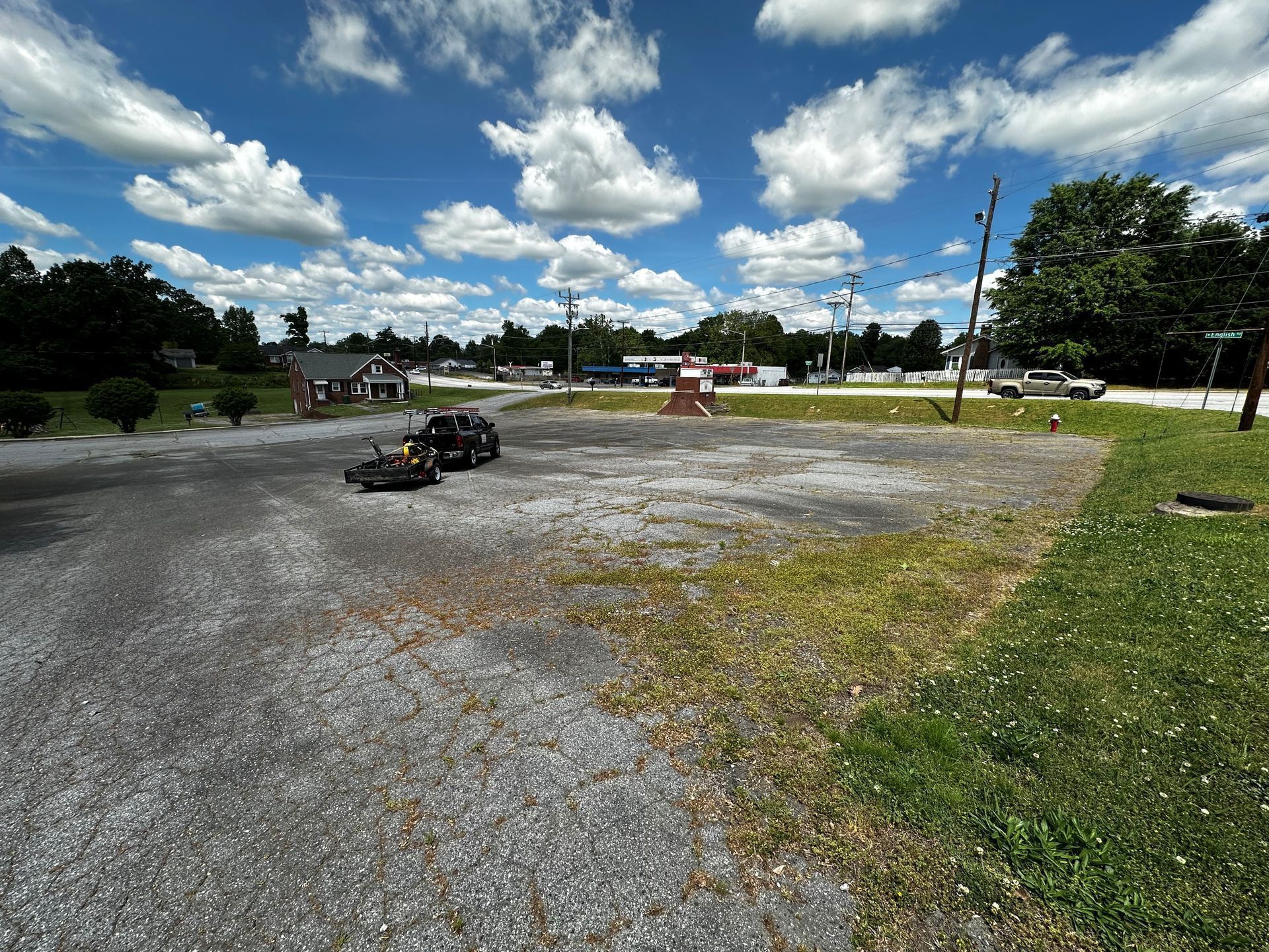 A go kart is driving down a gravel road in a parking lot.