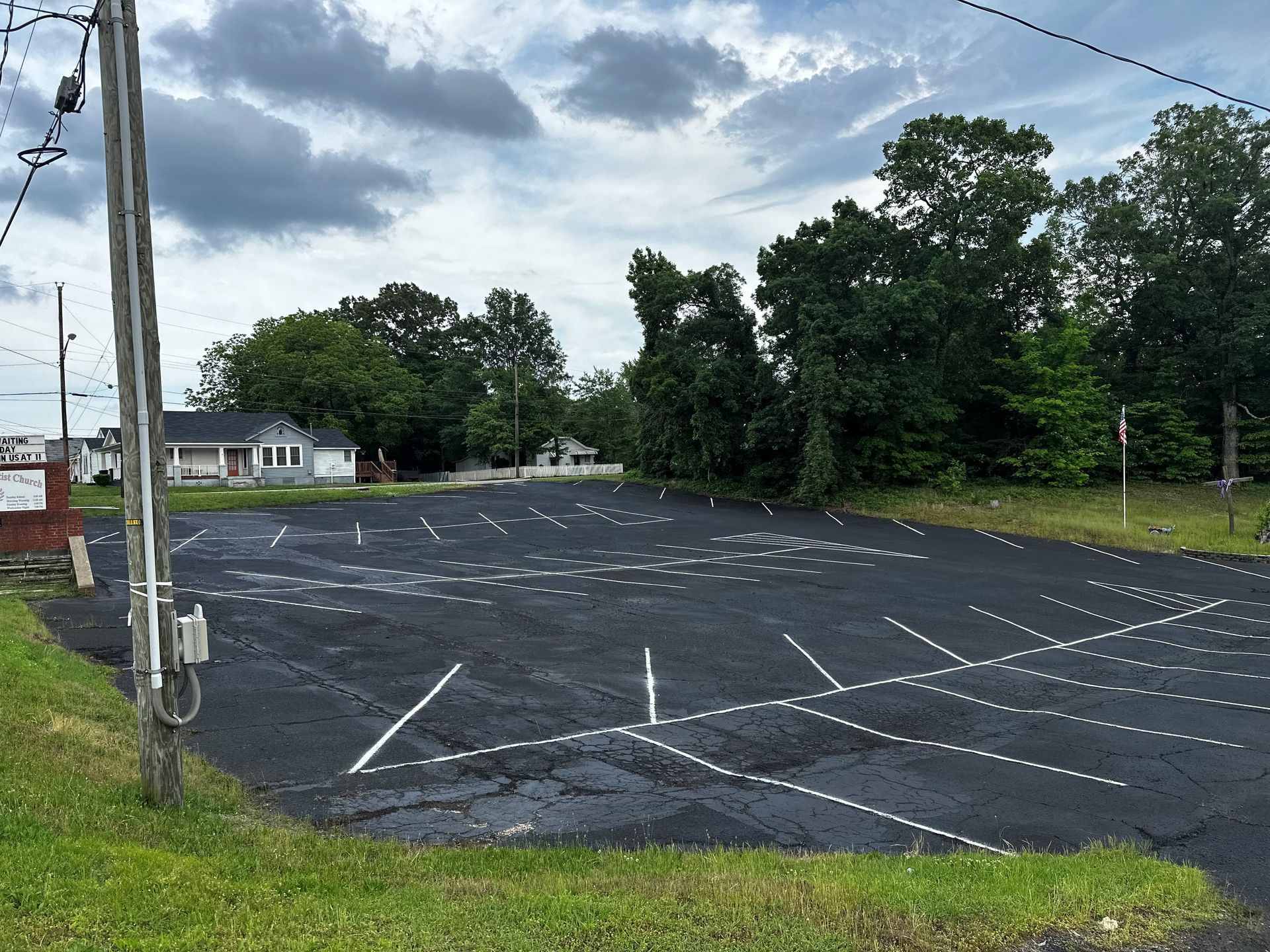 An empty parking lot with a house in the background