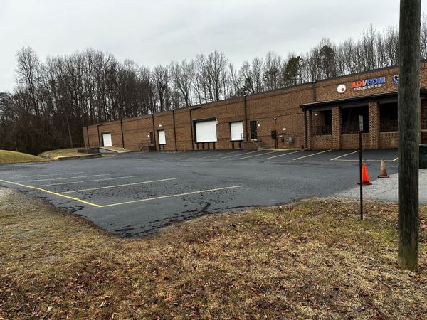 A large brick building with a parking lot in front of it.