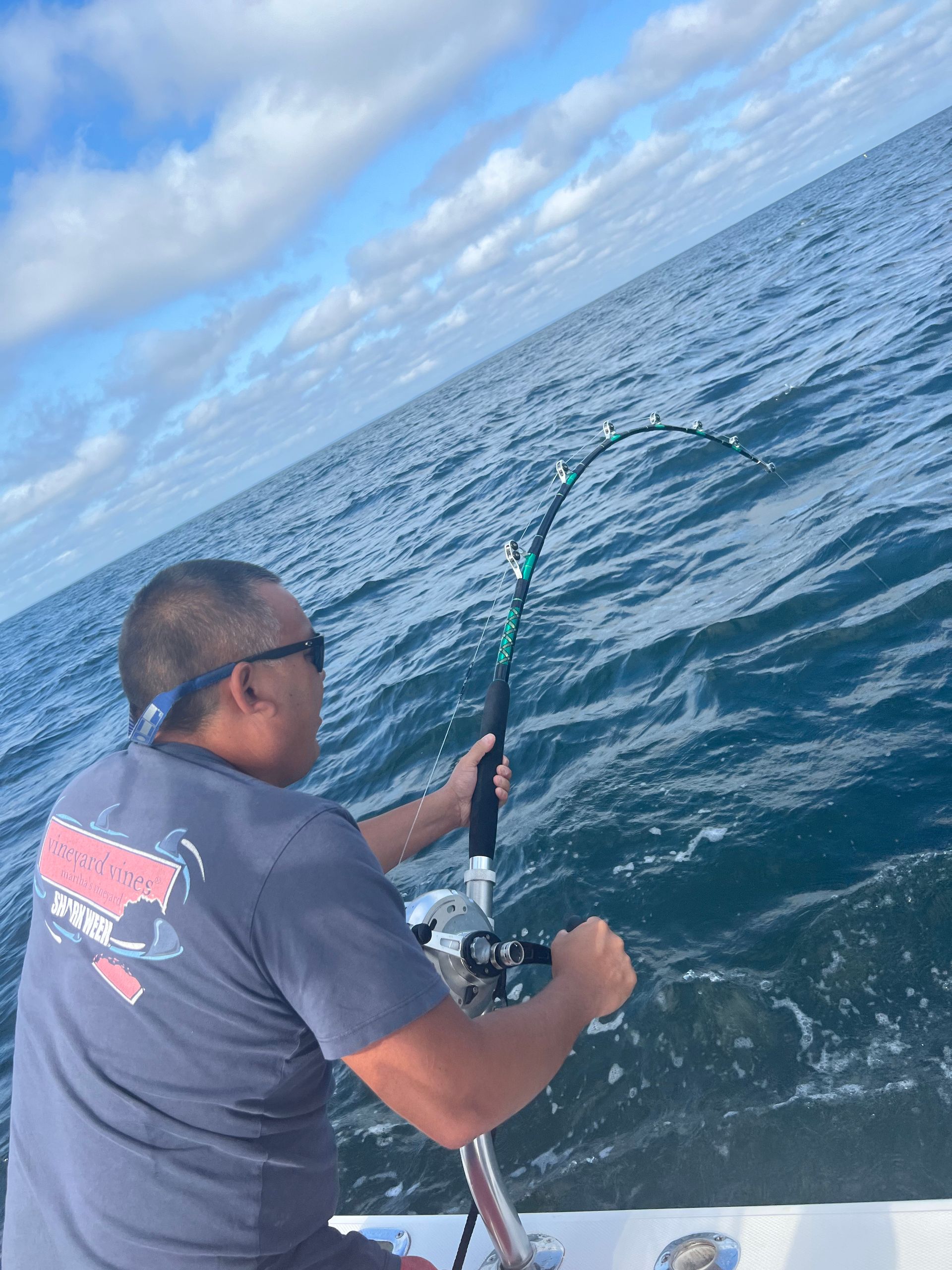 A man is fishing in the ocean on a boat.