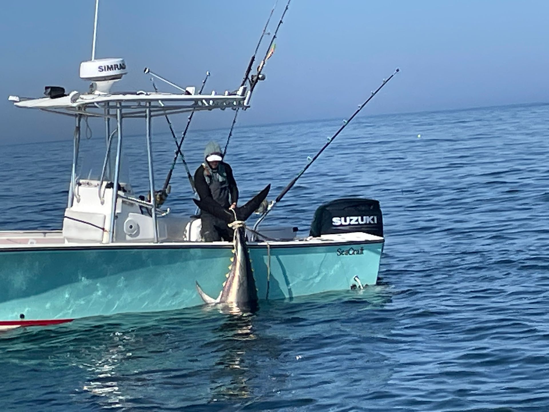 A man is fishing in the ocean on a boat.