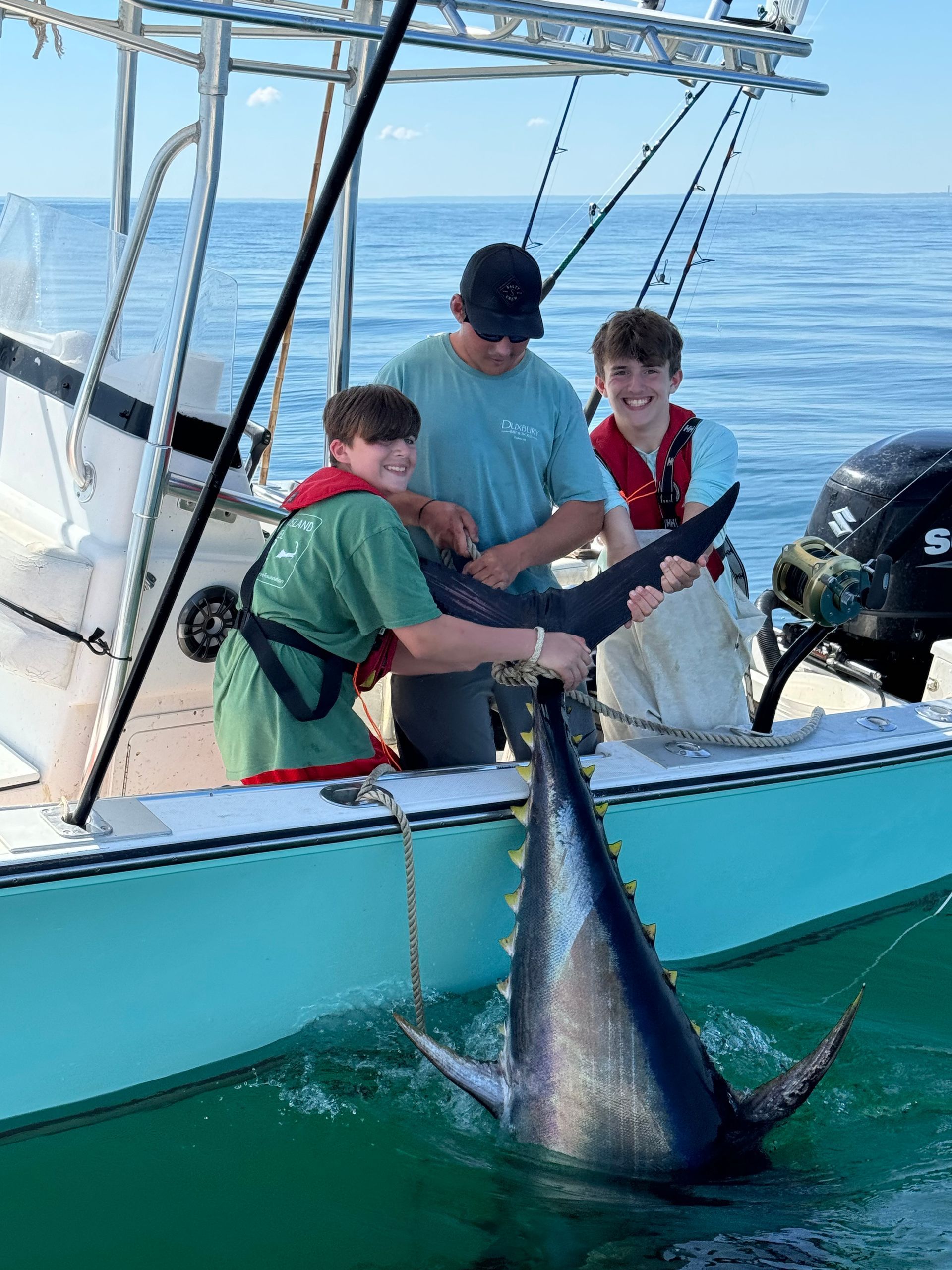 A group of people are fishing in the ocean on a boat.