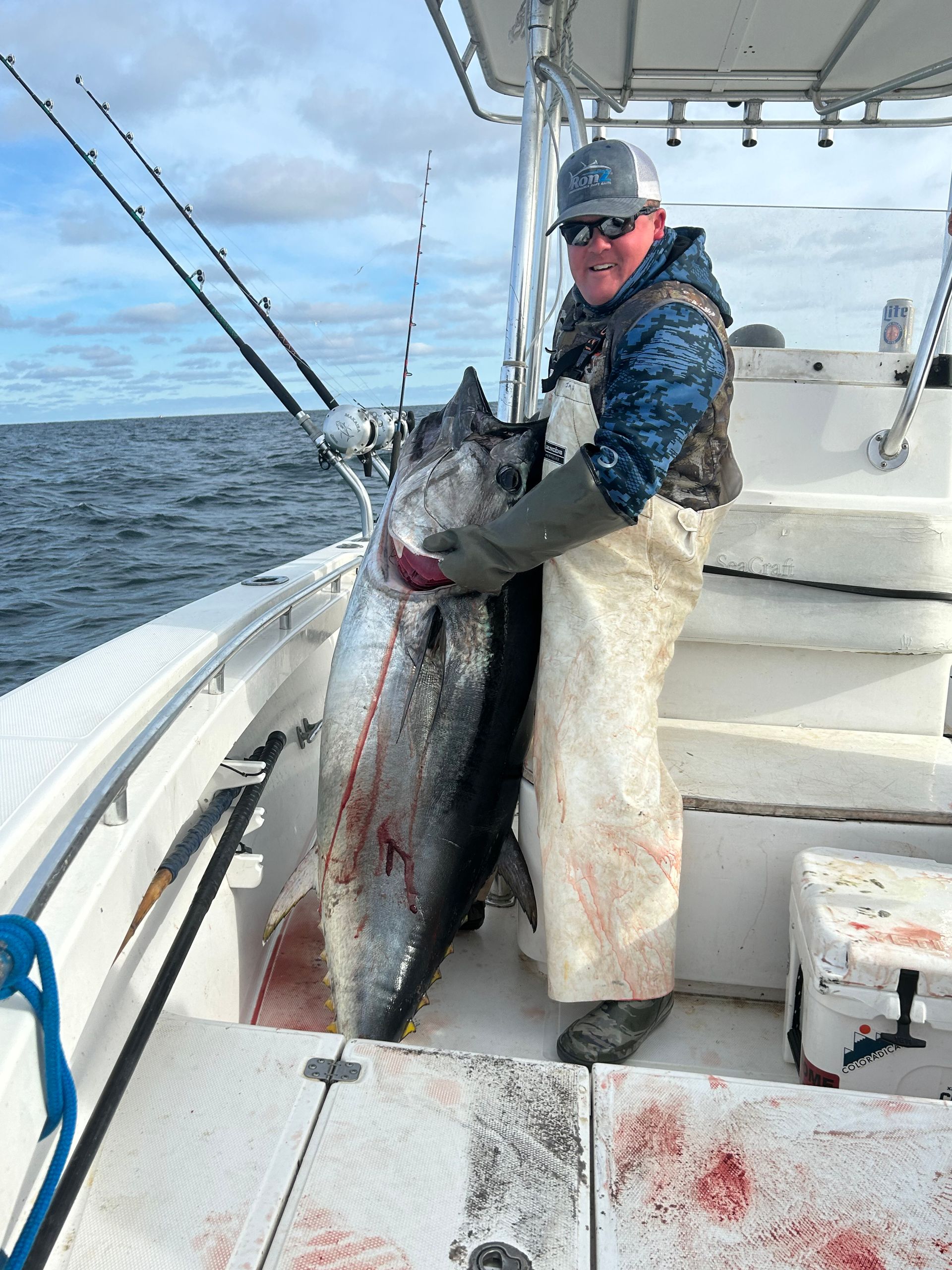 A man is holding a large fish on a boat.