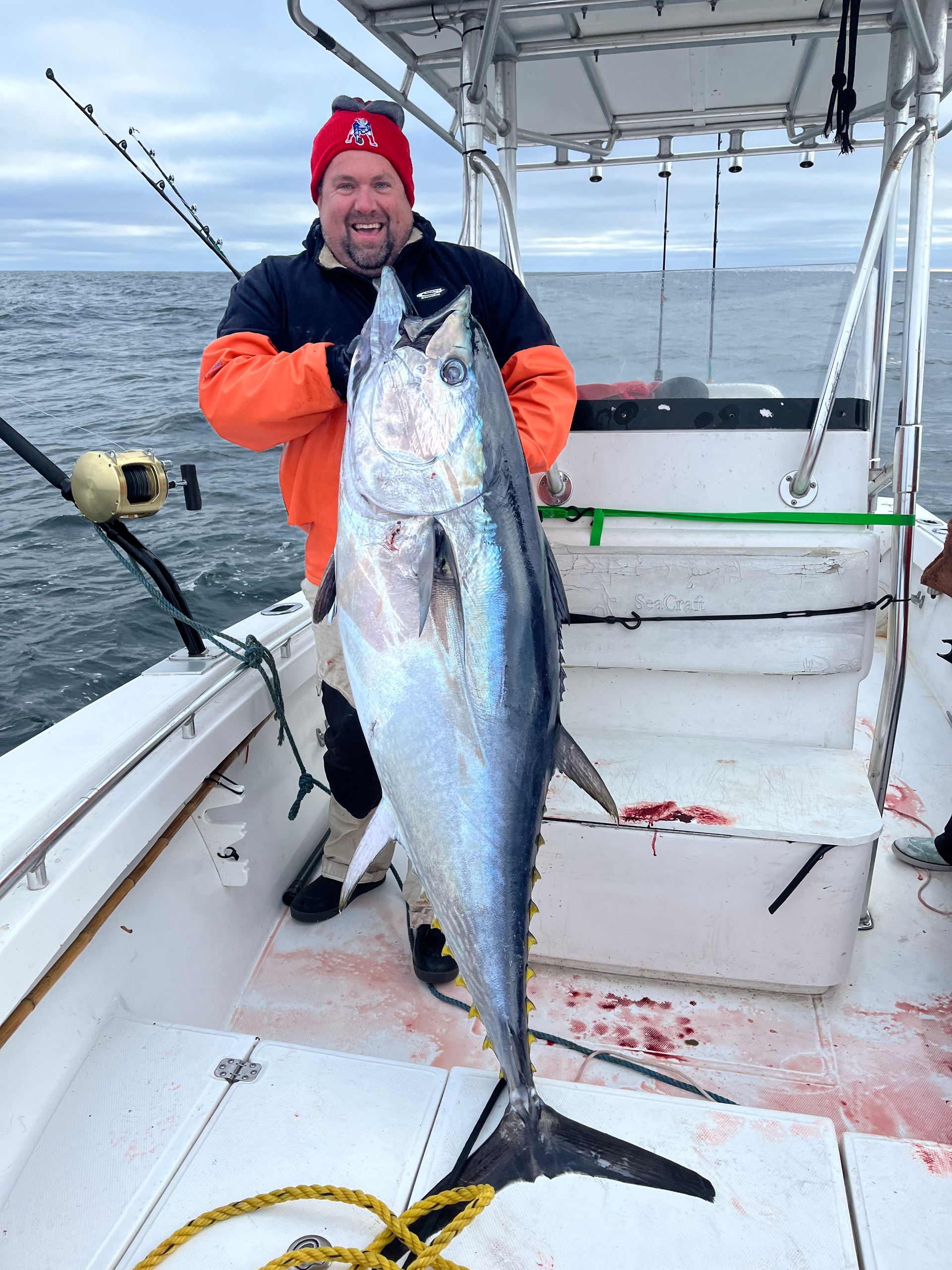 A man is holding a large fish on a boat.