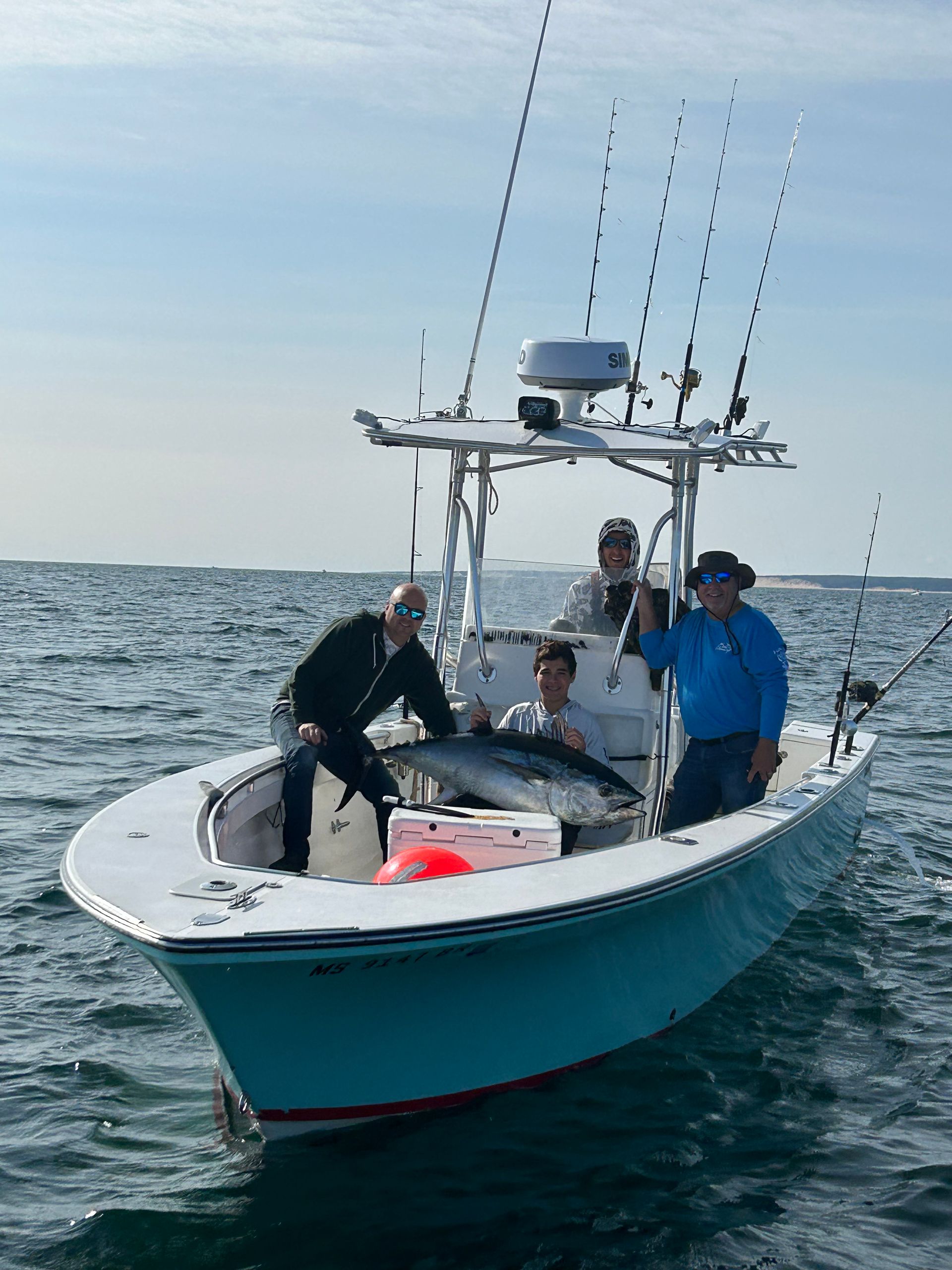 A group of people are fishing on a boat in the ocean.