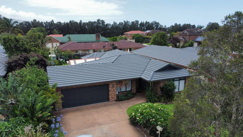 An Aerial View Of A House With A Roof That Is Surrounded By Trees — The Gutter Guy NSW in Corrimal, NSW