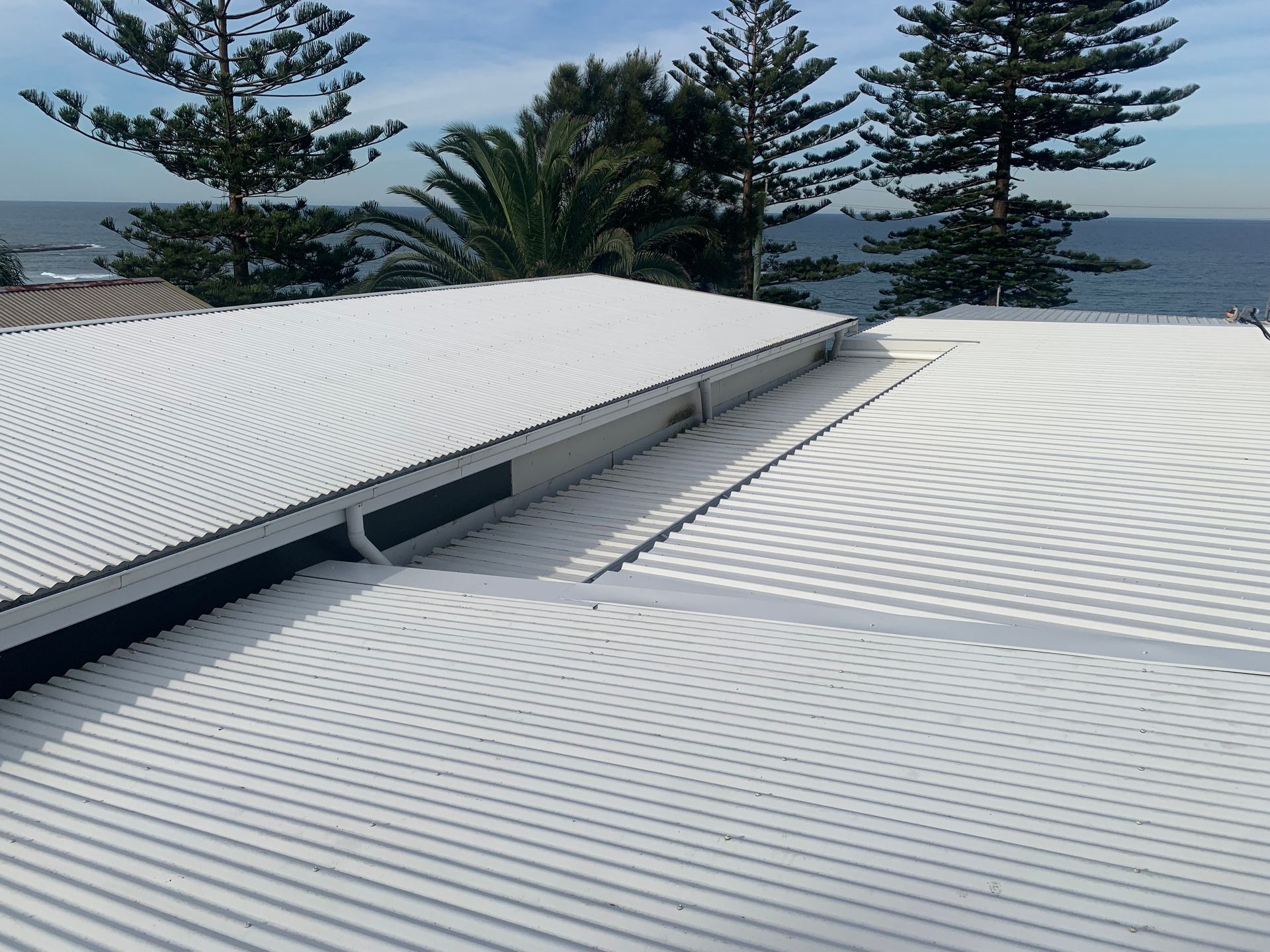 The Roof Of A White House With A Blue Sky — The Gutter Guy NSW in Tarrawanna, NSW