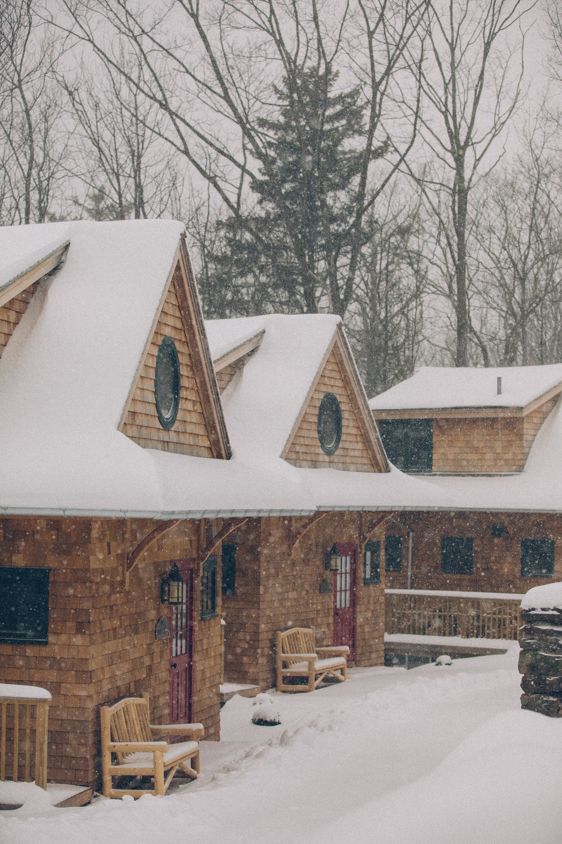 A snowy house with a truck parked in front of it