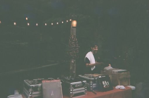A man is sitting at a table with a microphone in a dark room.