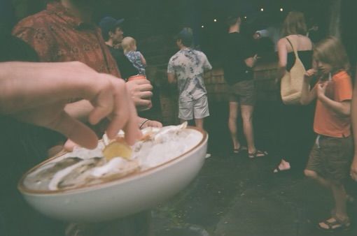 A person is holding a bowl of food in front of a crowd of people.