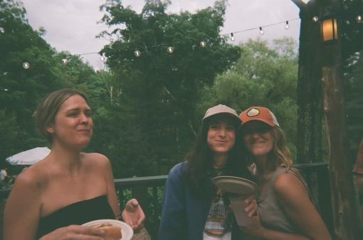 Three women are sitting at a table with plates of food.